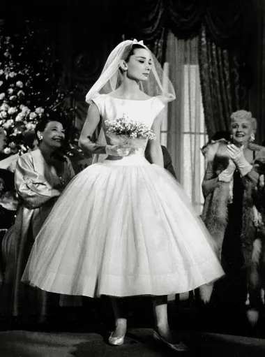 Ova vjenčana haljina modne kuće Givenchy nije bila jedina koju je Audrey Hepburn nosila u svom životu, jer je jednu odabrala i za vlastito vjenčanje, ali je svakako ostala upisana u povijest mode kao kultna kreacija. Haljinica dužine do iznad gležnjeva, s punom suknjom tila i sa lagano spuštenim strukom ušla je u povijest najljepših filmskih vjenčanica svih vremena. 