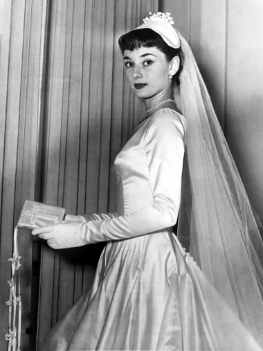 Legenda Hollywooda, Audrey Hepburn na ovoj fotografiji nosi svilenu zimsku vjenčanicu dizajnerice Zoe Fontane koja odiše bezvremenskom elegancijom. Nažalost, ova je fotografija snimljena tek nekoliko dana prije no što je glumičino vjenčanje na kojem je trebala prošetati u ovoj haljini bilo otkazano. Audrey se trebala udati za Jamesa Hansona, no sve je u zadnji čas palo u vodu. Neovisno o tome, mislimo da je ova zimska svadbena haljina zaslužila biti na ovoj listi zbog svoje nesvakidašnje ljepote. 