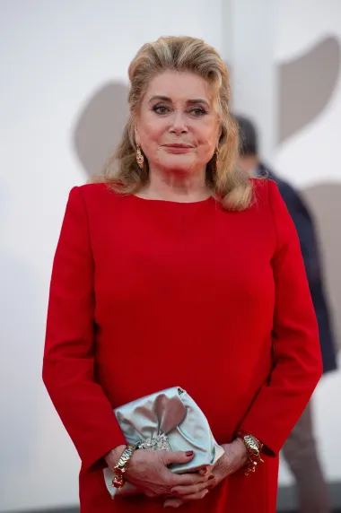 Catherine Deneuve, francuska filmska diva stigla je u Veneciju i pokazala da i u 79. godini života izgleda sjajno. Catherine je odjenula žarko crvenu haljinu do koljena,a look je upotpunila srebrom torbicom koja je podigla cijelu kombinaciju.