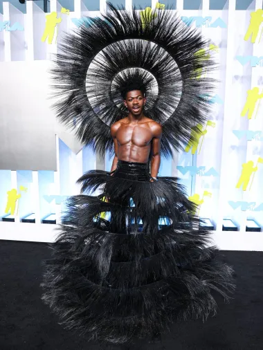 Reper Lil Nas X poznat je po svojim nesvakidašnjim kombinacijama na crvenim tepisima pa je teško izdvojiti samo jednu, no ona koju definitivno nitko nije očekivao je ona s dodjele VMA nagrada 2022. godine. Naime, reper se pojavio u crnom pernatom izdanju dizajnera Harrisa Reeda koje se sastojalo od neobičnog dodatka na glavi i crnih hlača s pernatom suknjom.