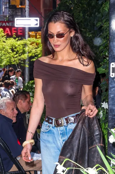 Model Bella Hadid nije prošla neprimijećeno jučer u New Yorku, pri odlasku iz  hotela Mercer. Modna zvijezda snimljena je u chic outfitu koji se sastojao od smeđe &quot;off shoulder&quot; prozirne majice, poderanih traperica i upečatljivih modnih dodataka. U ruci je nosila oversized smeđu kožnu jaknu vintage izgleda. 