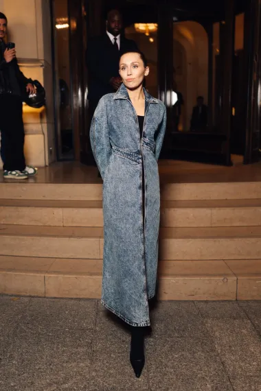 Traper baloner/haljina s prorezom i asimetričnim linijama ravnog kroja blago je padao do gležnja. Kaput ima jednostavan, ali sofisticiran dizajn, a Miley je upotpunila look crnim čizmama na visoku petu koje savršeno nadopunjuju cijeli outfit. 