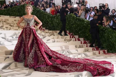 Blake Lively izgledala je božanstveno na Met Gali 2018. godine, čija je tema bila &quot;Nebeska tijela: Moda i katolička maštovitost&quot;. Uz ručno izrađenu krunu s aureolom koju je dizajnirala Lorraine Schwartz, nosila je raskošnu haljinu po mjeri iz ateljea Versace s impozantnim šlepom koji je kao da je stvoren za legendarne stepenice Met muzeja.
