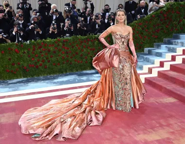 Blake Lively izgledala je uistinu kraljevski na Met Gali na kojoj je bila domaćin uz oskarovku Reginu King i zvijezdu Broadwaya Lina-Manuela Mirandu. Blistala je s krunom, opernim rukavicama i visećim naušnicama, uz raskošnu haljinu iz ateljea Versace. Posebno je oduševila iznenadnom transformacijom haljine — velika mašna se razvila u dugi plavi šlep, pružajući pravi modni spektakl na stepenicama Met muzeja.