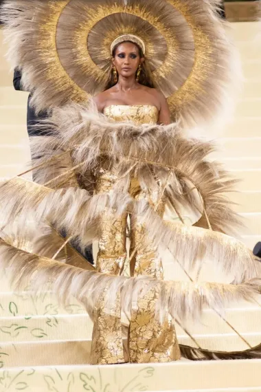 Haljina Dolce &amp; Gabbana koju nosi ovaj supermodel zahtijevala je 400 sati izrade. Zlatna suknja nalik kavezu, ukrašena je perjem u kombinaciji sa zlatnim perjem bez rukava i ogromnim ukrasom za glavu, jednostavno je očaravajuća. 