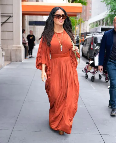 58-godišnja Salma Hayek na ulicama New Yorka pojavila se u žarko narančastoj drapiranoj širokoj haljini. Strukirani dio naglasio je njezinu figuru, a voluminozni rukavi učinili su haljinu još efektnijom i dramatičnijom. Look je zaokružila visokom platformom  i sunčanim naočalama. 
