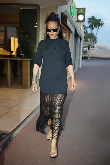 Gornji dio jednostavne haljine, djeluje efektnije uz dramatične crne rese. Rihanna je outfit začinila prozirnim sandalama na petu. 