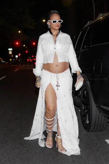 Nakon što je oduševila na Met Gali u potpuno bijelom izdanju, Rihanna je ostala vjerna istoj paleti boja i za outfit na after partyju. Pokazala je svoj prepoznatljiv trudnički stil koji ističe trbuščić, noseći bijelu maksi suknju s visokim prorezom do gotovo bokova i kratku jaknu, kreacije brenda Chrome Hearts. 