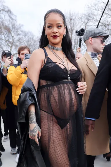 Outfit koji je privukao sve poglede na Dior reviji. Rihanna je odabrala haljinu negliže stila od tila u crnoj boji. Ispod prozirne tkanine nazirao se crni čipkasti gudnjak. Izazovni outfit osvježila je srebrnim nakitom i kožnim balonerom koji je nonšalantno ogrnula na sebe. 